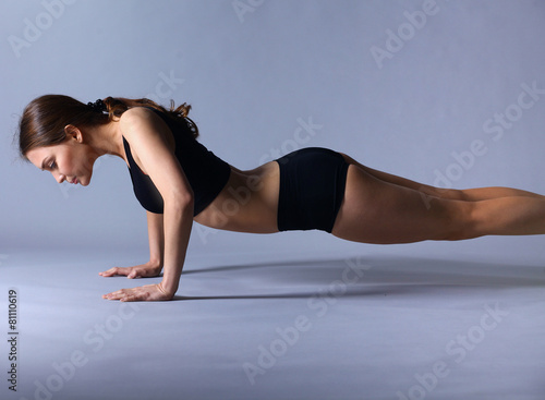 Portrait of young woman doing push ups
