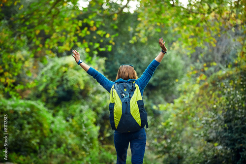 Woman hiker  standing outside in forest with backpack