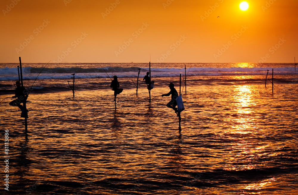 Silhouettes of the traditional stilt fishermen at the sunset nea