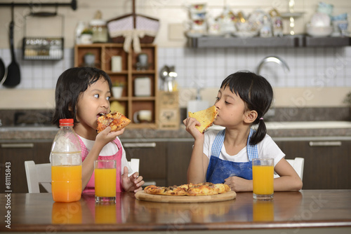 Two Little Girls Eating Pizza