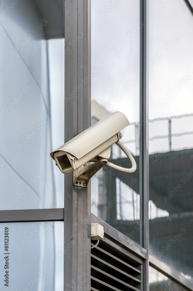 Old security camera on a glass wall. Old security camera on a glass wall.