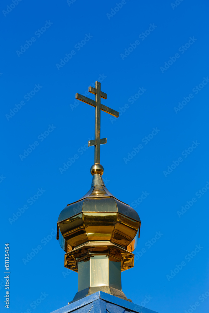 Church dome with a cross against,  blue sky