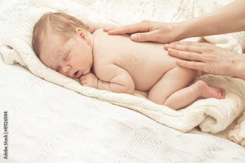 Mother massaging infant boy