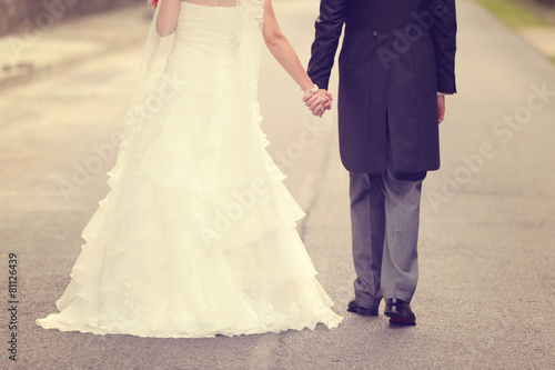 Bride and groom walking on road © hreniuca