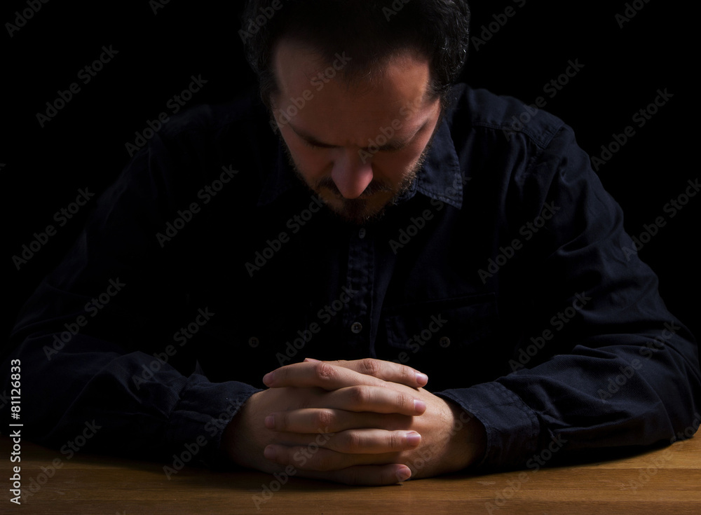 Depressed man with hands on desk