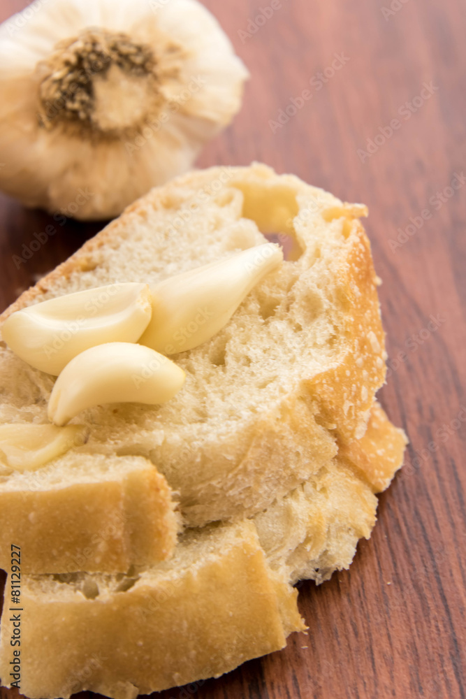 fresh baked loaf of bread with whole cloves of roasted garlic