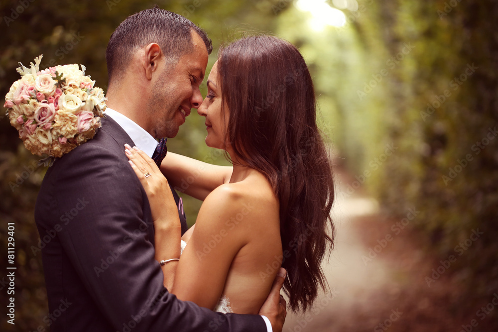 Bride and groom embracing in the garden Bride and groom embracing in the garden