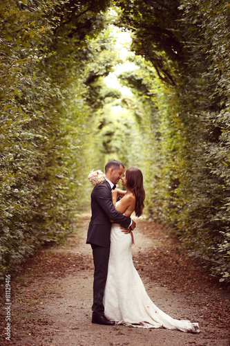 Vertical photograph of a bride and groom embracing Fototapet