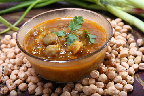 indian spicy chana masala with raw chickpeas and green onion photo