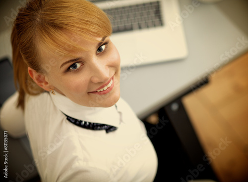Portrait of businesswoman sitting at desk with a laptop