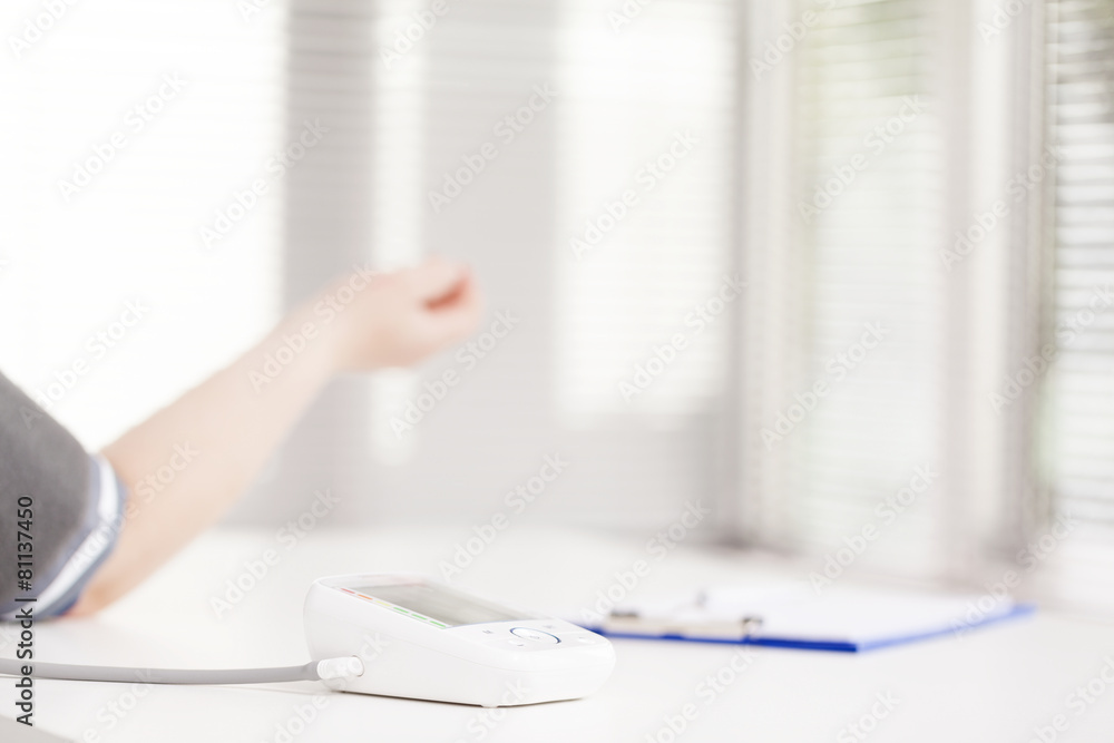 Fototapeta premium Woman measuring blood pressure at the clinic