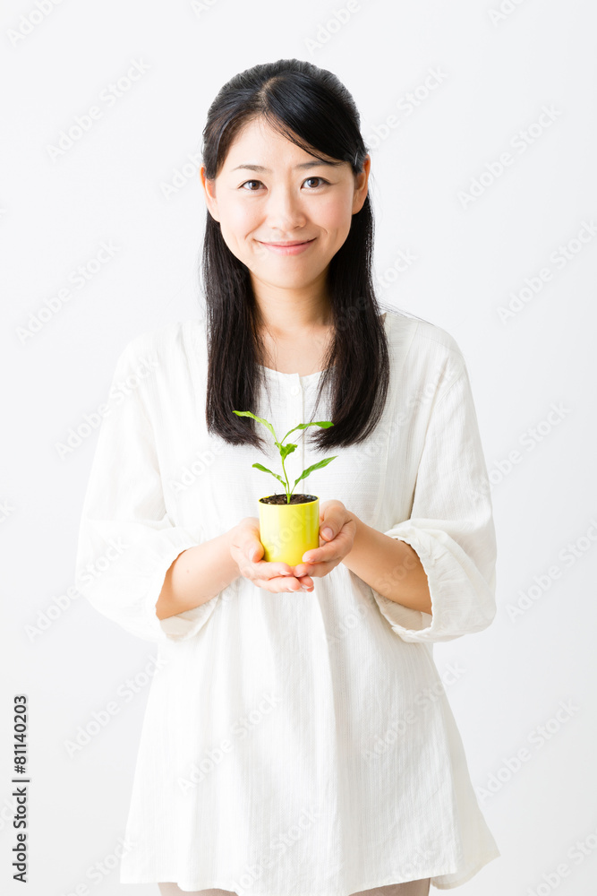 young asian woman holding green plant young asian woman holding green plant