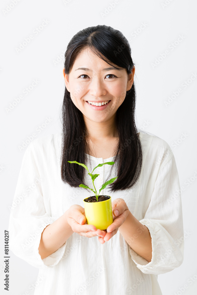 young asian woman holding green plant young asian woman holding green plant