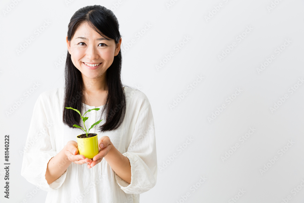 young asian woman holding green plant young asian woman holding green plant