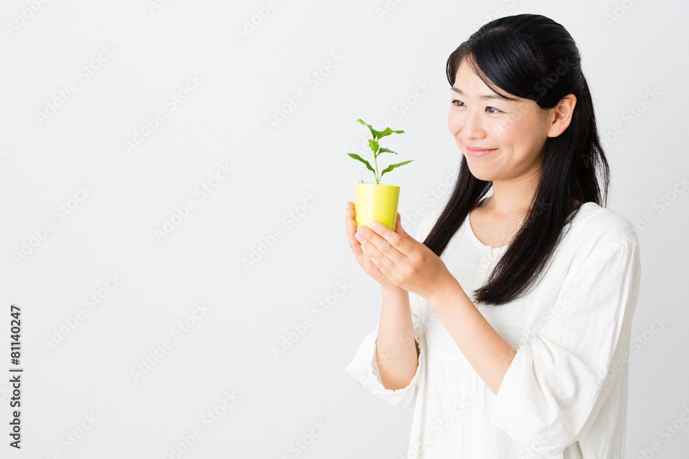 young asian woman holding green plant