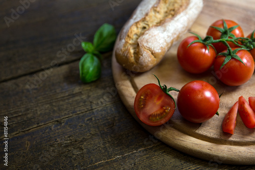 Tomaten mit rustikalem Brot und Basilikum auf Holztisch