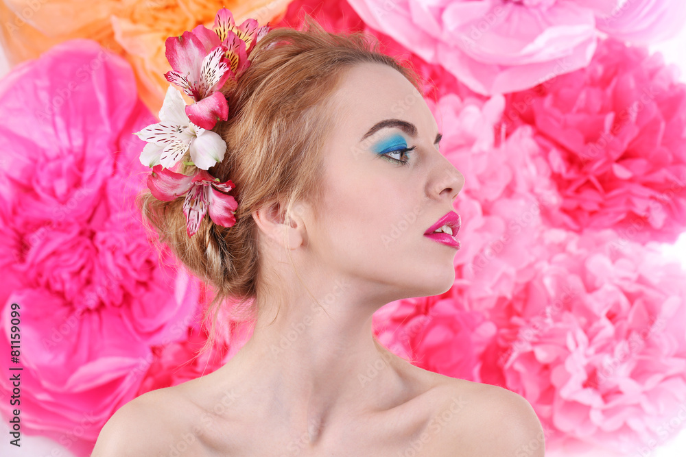 Portrait of young woman with flowers in hair on bright pink background Portrait of young woman with flowers in hair on bright pink background