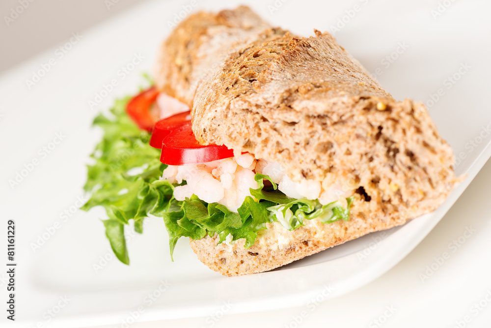 Prawn sandwich on white plate angled
