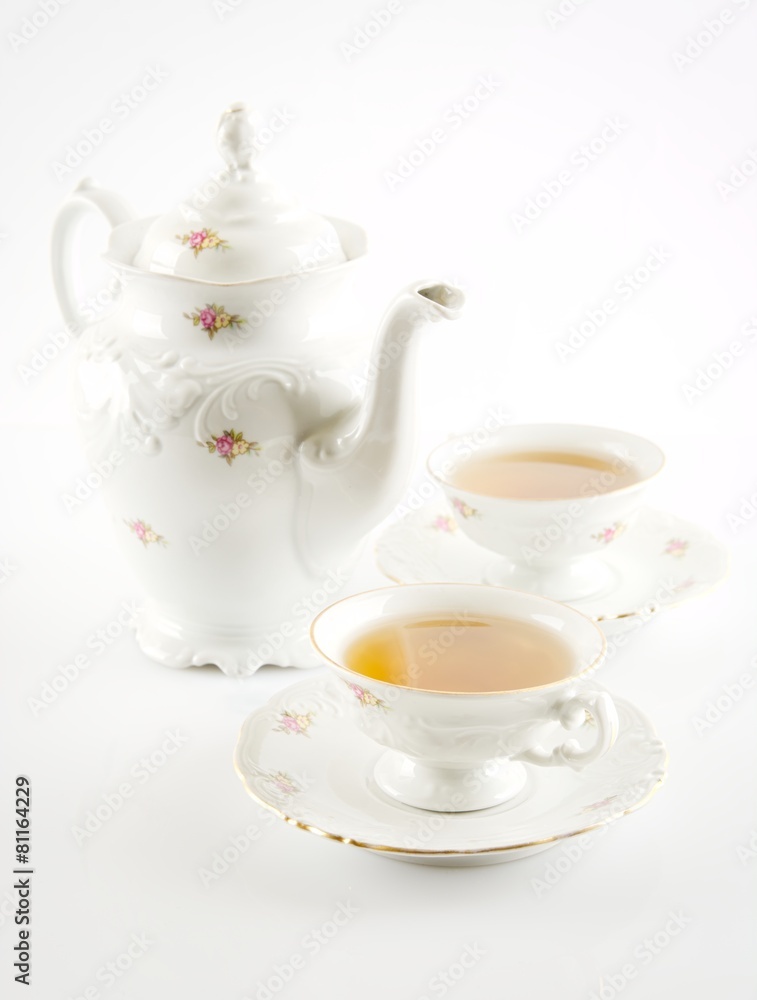 Old-style kettle with two cups of tea on white background