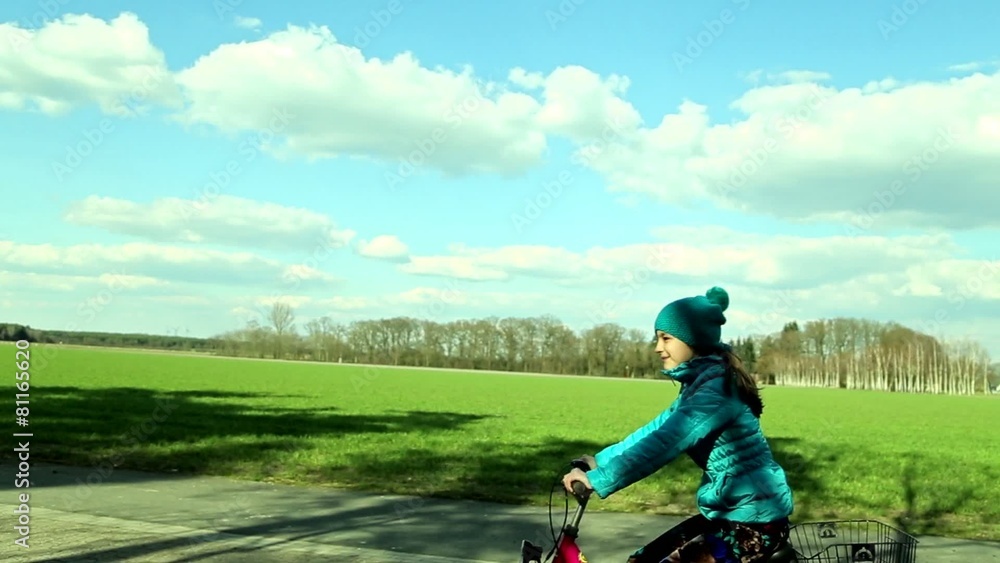 Smiling teenage girl riding bicycle in a park Smiling teenage girl riding bicycle in a park