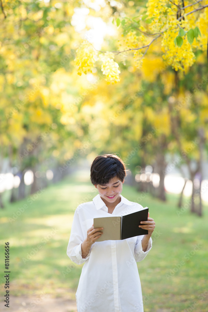 portrait of young beautiful asian woman standing in yellow flowe portrait of young beautiful asian woman standing in yellow flowe