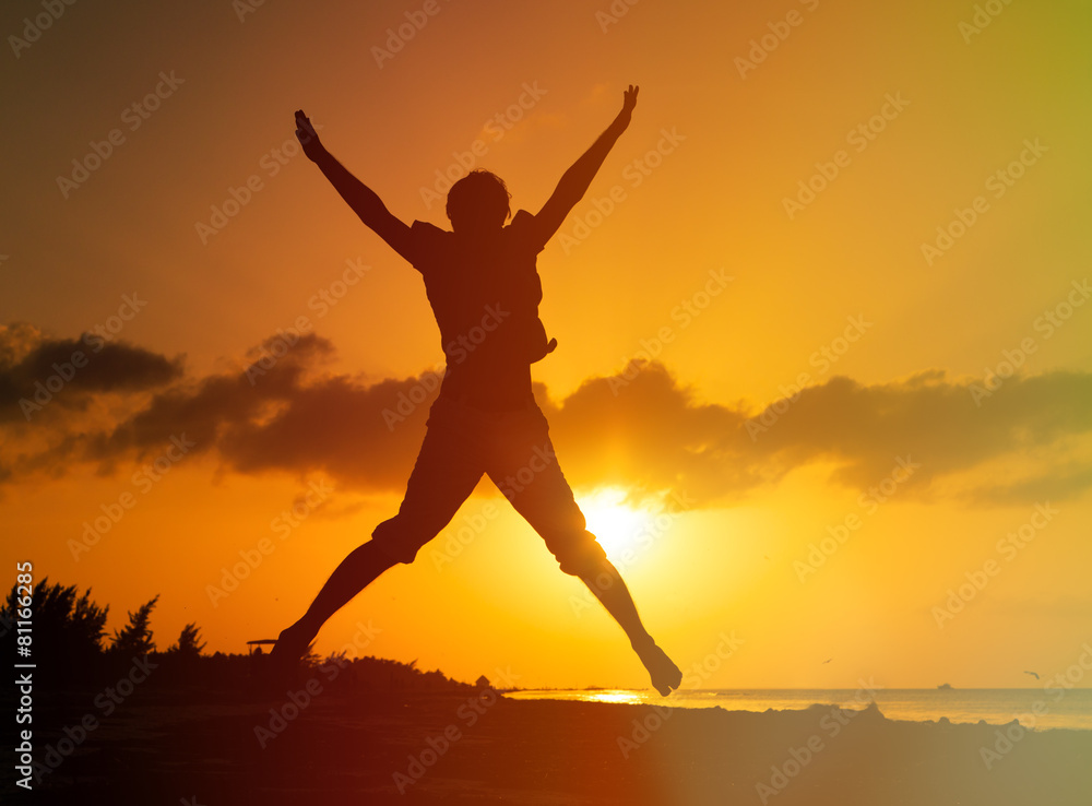 happy man jumping on sunset beach