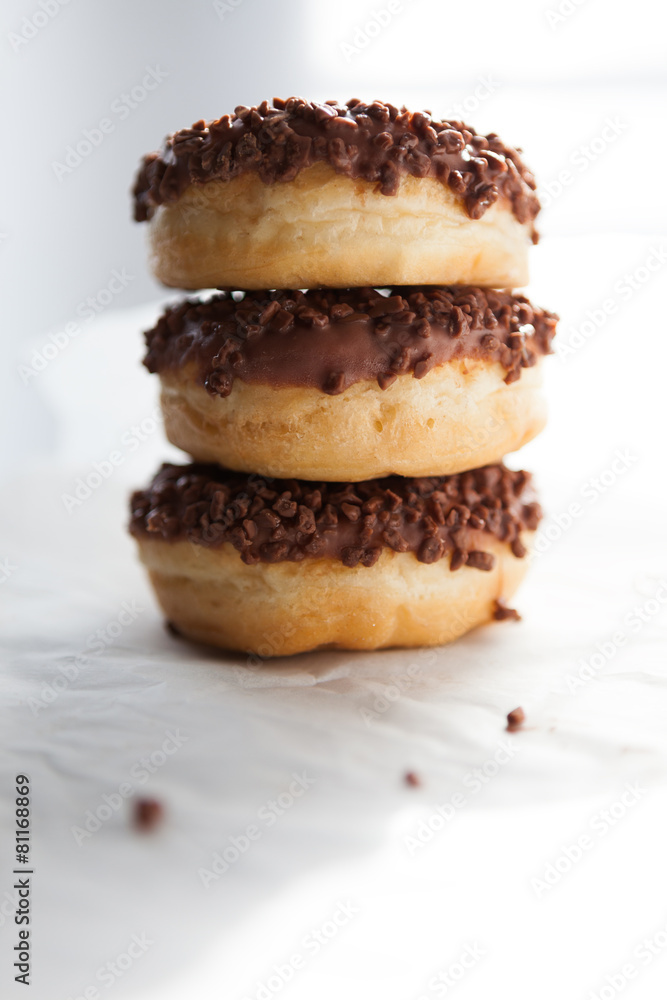 Three chocolate doughnuts on the white background Three chocolate doughnuts on the white background