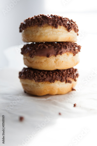 Fototapeta Three chocolate doughnuts on the white background