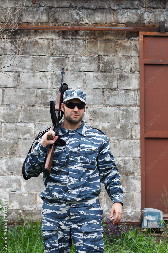 Fototapeta premium Caucasian military man with black sunglasses in urban warfare ho