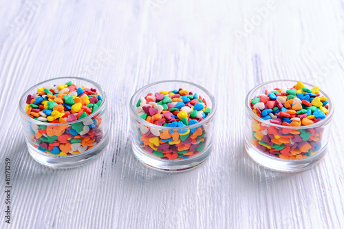 Colorful sprinkles in bowls on table close-up