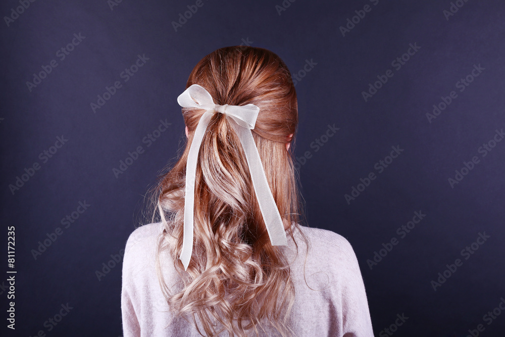 Naklejka premium Female hairstyle with color ribbon on dark background