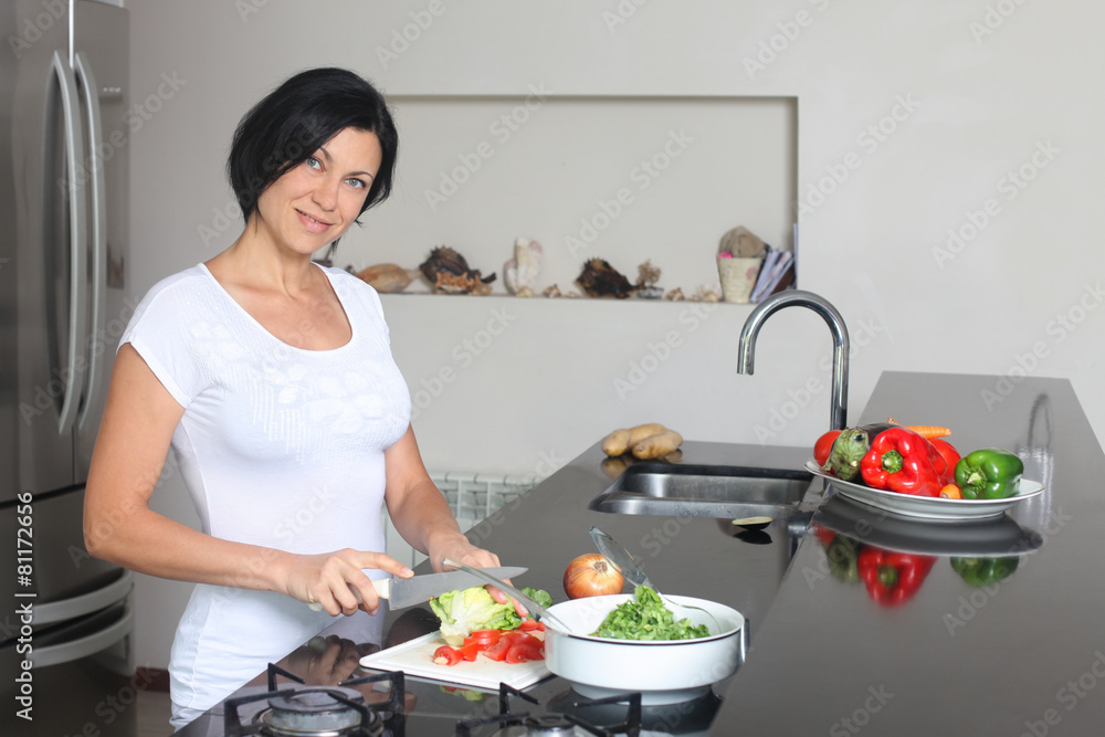 smiling housewife making fresh salad in the kitchen smiling housewife making fresh salad in the kitchen