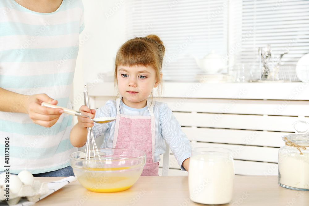 Little girl preparing cookies with mother in kitchen at home Little girl preparing cookies with mother in kitchen at home