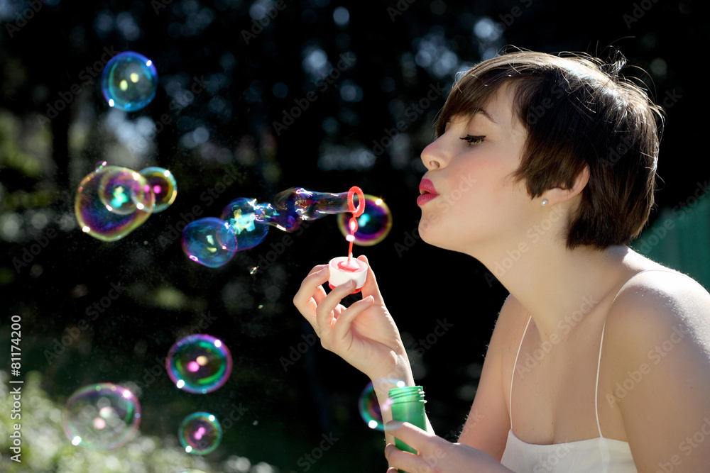 Woman blows soap bubbles