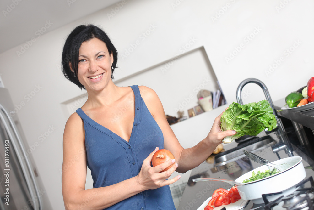 smiling housewife making fresh salad in the kitchen smiling housewife making fresh salad in the kitchen