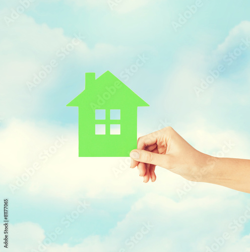 hand holding green paper house
