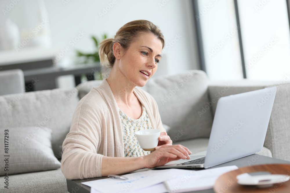 Middle-aged woman working from home on laptop Middle-aged woman working from home on laptop