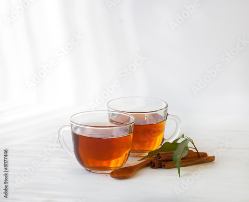 Glass cup of black tea with cinnamon sticks