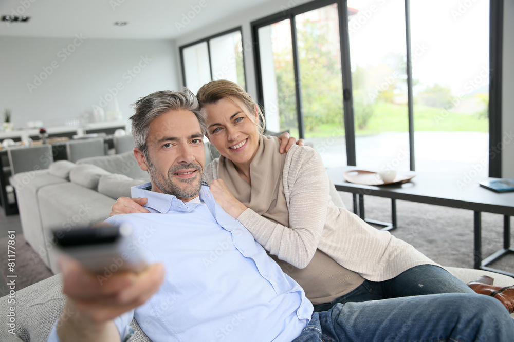 Middle-aged couple in living-room watching television Middle-aged couple in living-room watching television