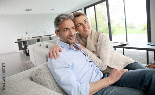 Portrait of 45-year-old couple relaxing in modern house