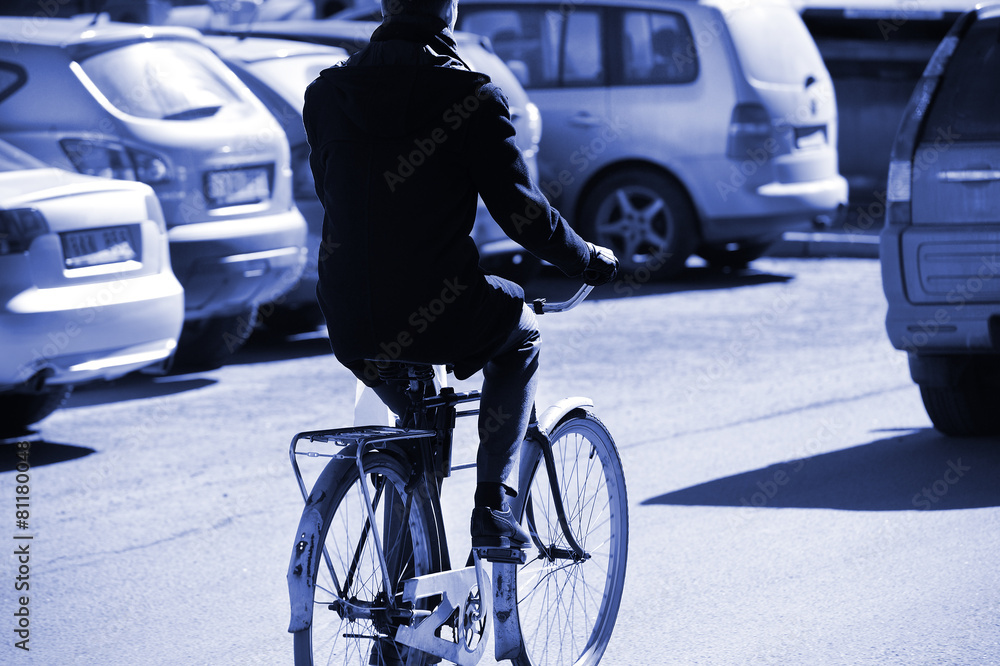 Fotografie Man on bicycle in evening traffic