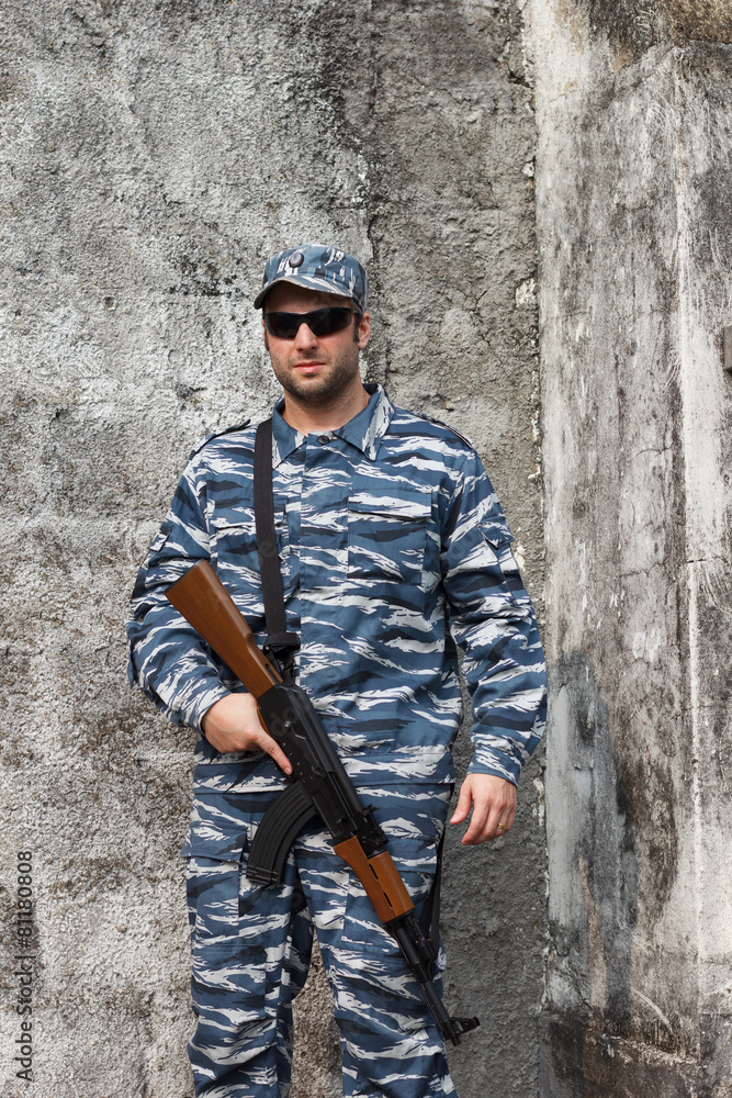 Caucasian manin urban warfare holding rifle Caucasian manin urban warfare holding rifle