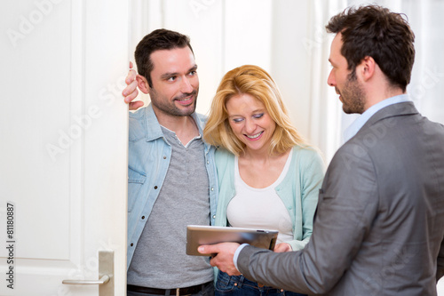 Real estate agent present project on tablet to a young couple