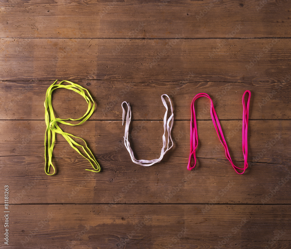 Shoelaces run sign on a wooden floor background Shoelaces run sign on a wooden floor background