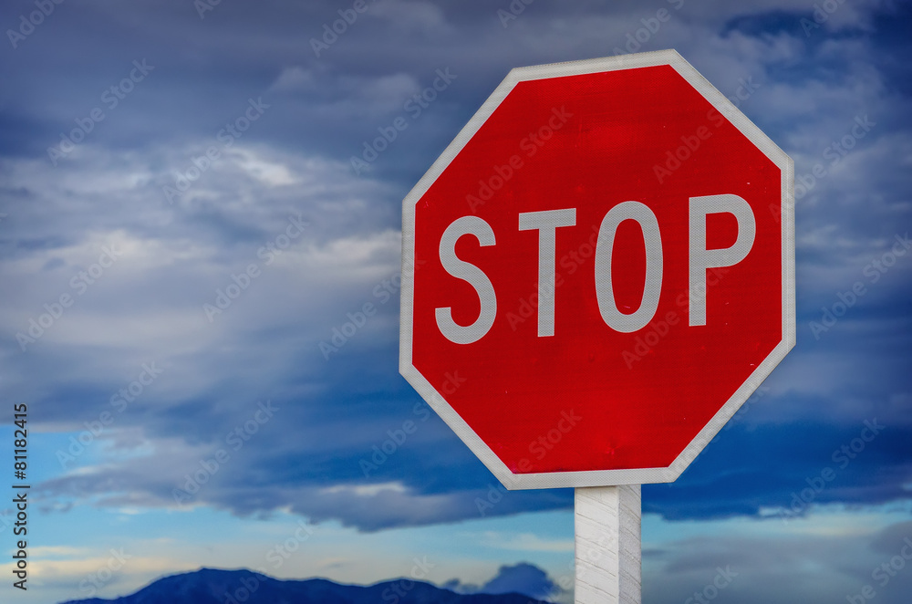 roadside red stop sign on a cloudy background.