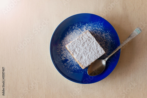 Piece of cake on a plate on white table background.