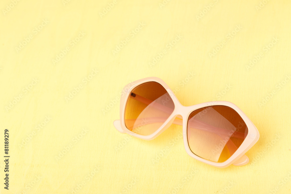 sunglasses on yellow wooden table sunglasses on yellow wooden table