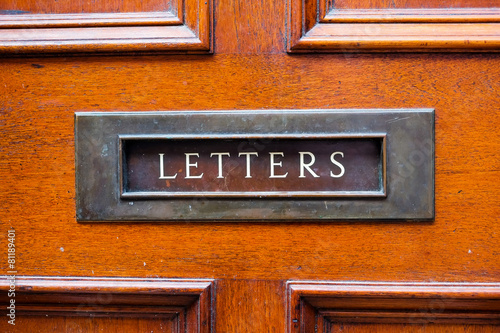 Foto Old wooden door and brass letterbox