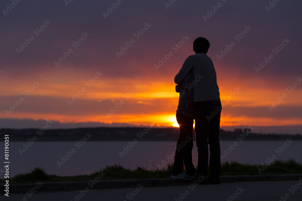 Sillhouette of couple holding together at sunset