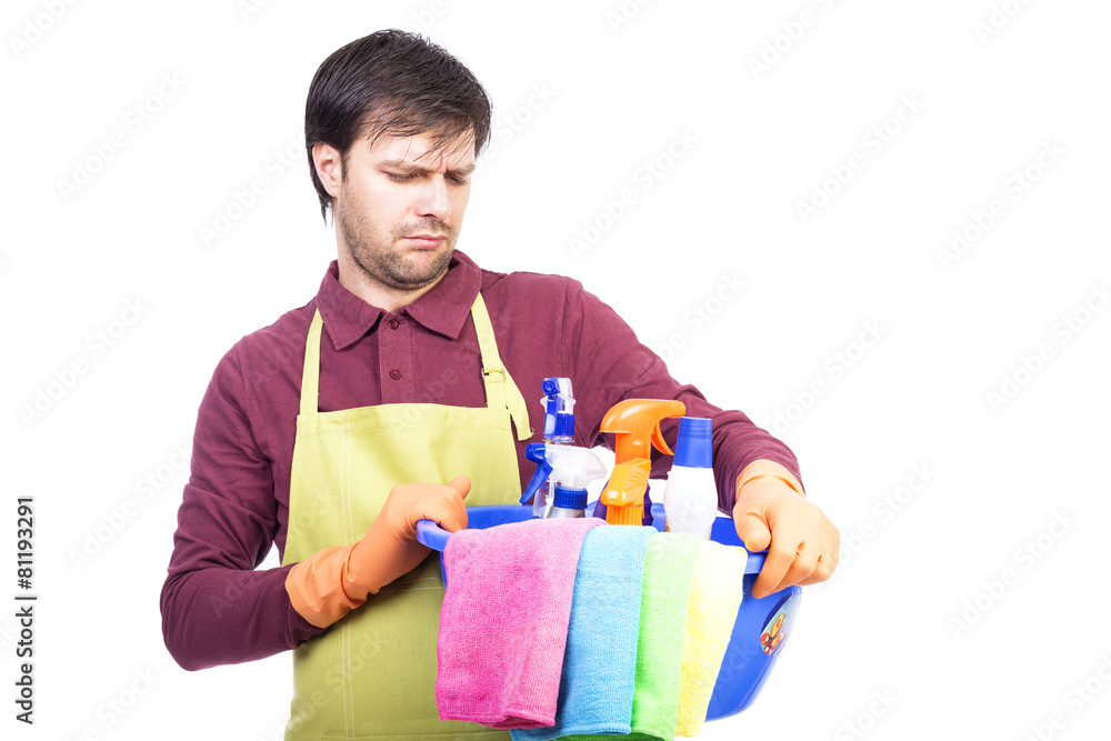Unhappy young man with apron and cleaning equipment Unhappy young man with apron and cleaning equipment